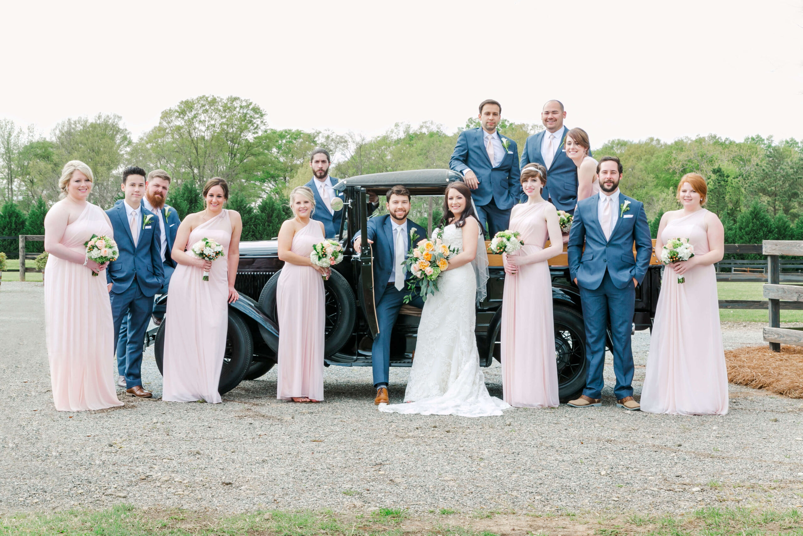 Bridal party poses around a vintage truck.