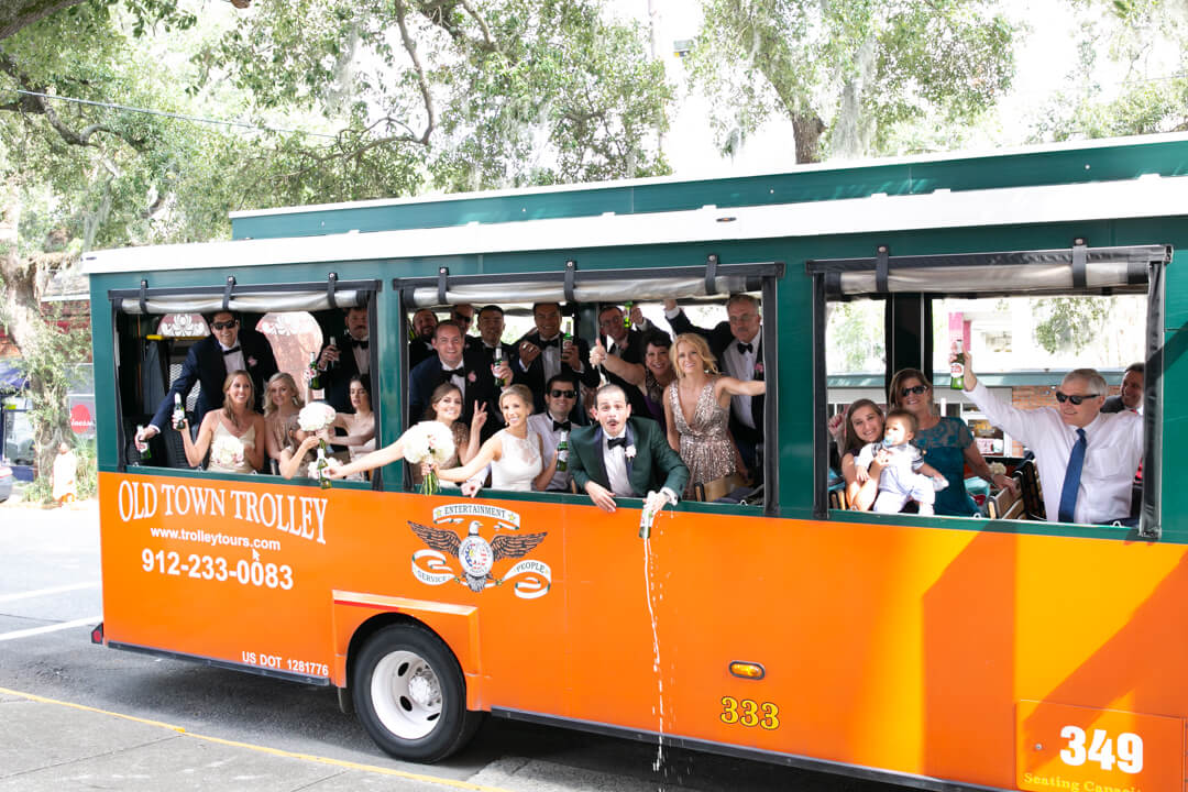 The wedding party celebrates in the town trolley with cheers and beers on the way to the reception. Little Rock Arkansas
